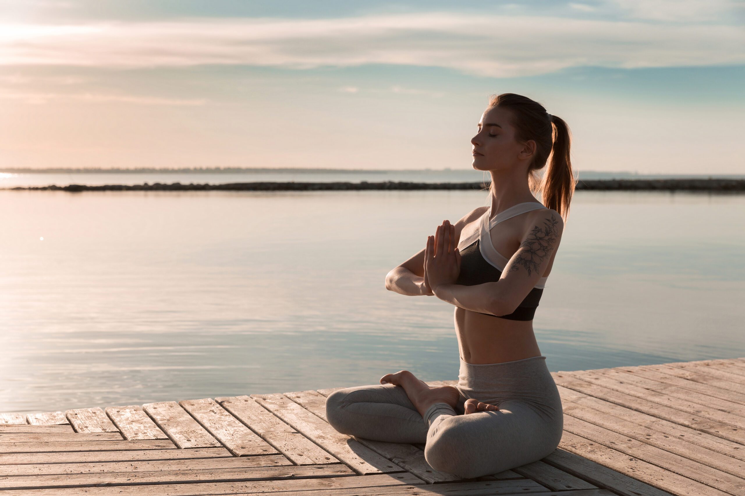 Picture of young sports lady at the beach make meditate exercises.